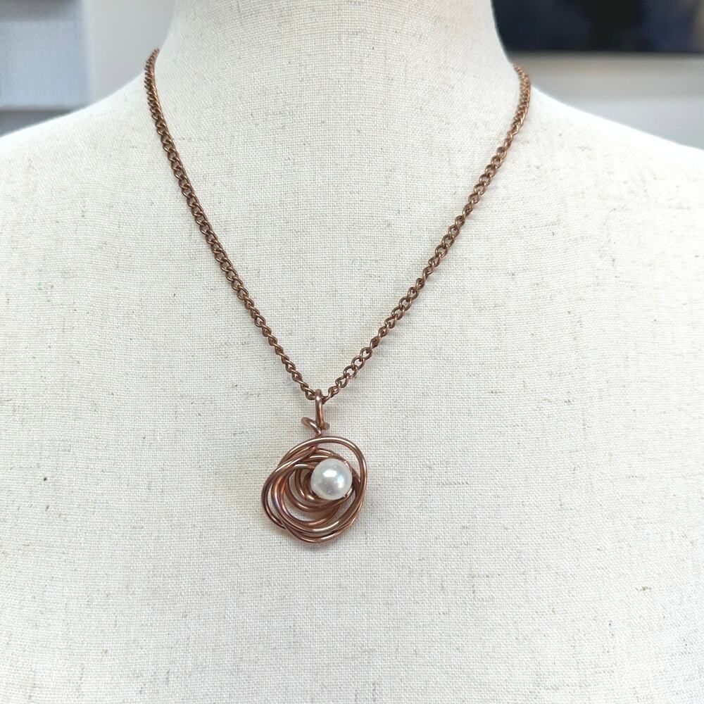 Cooper wire wrapped nest surrounds a pink opal copper tone chain. 16” new